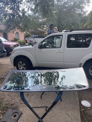 Photo of technician fixing a windshield in residential area